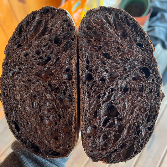Two halves of Black Death bread loaf showing texture and crumb.