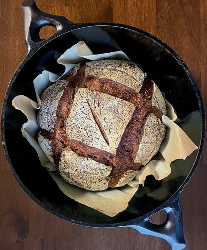 Loaf of Black Death bread in a black cast iron skillet 